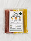 A clear plastic bag containing Sea Moss Fruit Pops by Sea Juices, with a white label in the center showing flavor icons and text. The pops are visible through the packaging as reddish-brown and yellow strips, set against a plain white background.